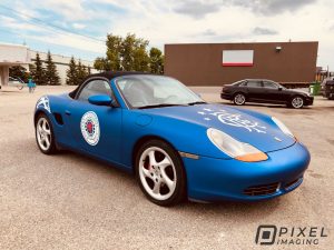 Vinyl car wrap on a blue Porsche car with side decals, hood decals, and fender decals
