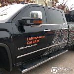 Vinyl lettering and a custom-printed partial vinyl vehicle wrap on a GMC Denali HD pickup truck.
