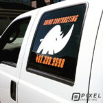 Vinyl window lettering, vinyl logo decal, and phone number decal on a company work pickup truck.