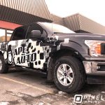 A partial vinyl vehicle wrap on the side of a Ford pickup truck.