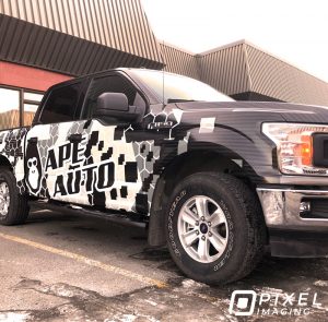 A custom-printed partial vinyl vehicle wrap on the side of a Ford pickup truck.
