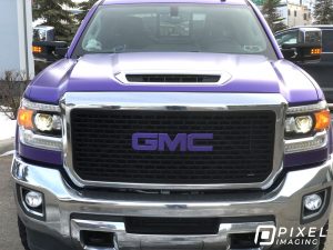 Pearlescent-purple vinyl vehicle wrap on a GMC 3500 HD pickup truck. The GMC emblem is wrapped too.