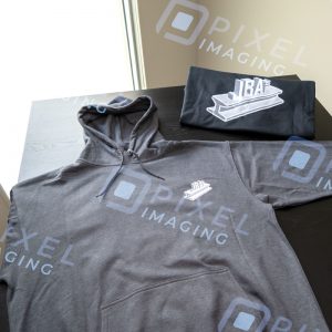 Custom hoodies Calgary: A pair of custom-printed hoodies displayed on a table featuring the logo of a Calgary business.