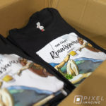 A box full of heat press vinyl T-shirts showing art and the text "The Craft Renaissance Project."