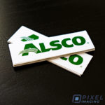 Custom Stickers Calgary: A stack of self-adhesive stickers bearing the logo of a Calgary business.